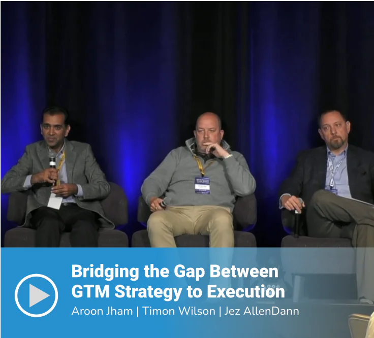 Video thumbnail of a panel session titled "Bridging the Gap Between GTM Strategy to Execution" featuring speakers Aroon Jham, Timon Wilson, and Jez AllenDann seated on stage against a dark blue-lit backdrop