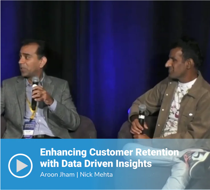 Video thumbnail of a panel discussion titled "Enhancing Customer Retention with Data Driven Insights" featuring speakers Aroon Jham and Nick Mehta seated on stage, each holding a microphone, against a dark blue draped background.