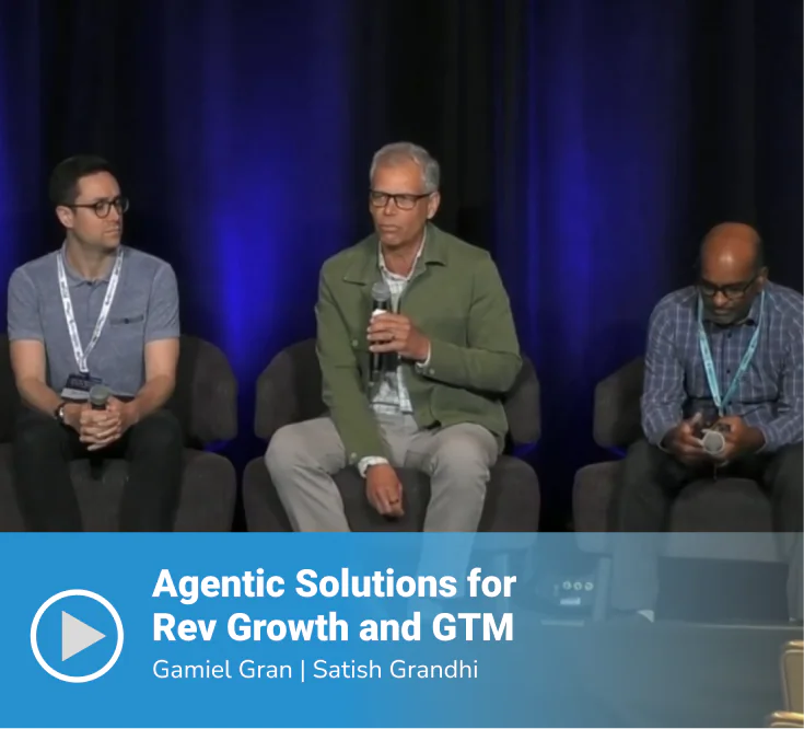Video thumbnail of a panel session titled "Agentic Solutions for Rev Growth and GTM" featuring speakers Gamiel Gran and Satish Grandhi, with three panelists seated on stage, the center speaker holding a microphone, against a dark blue-lit backdrop.